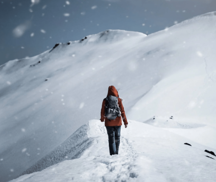 Person walking in snow, as part of cold-weather camping